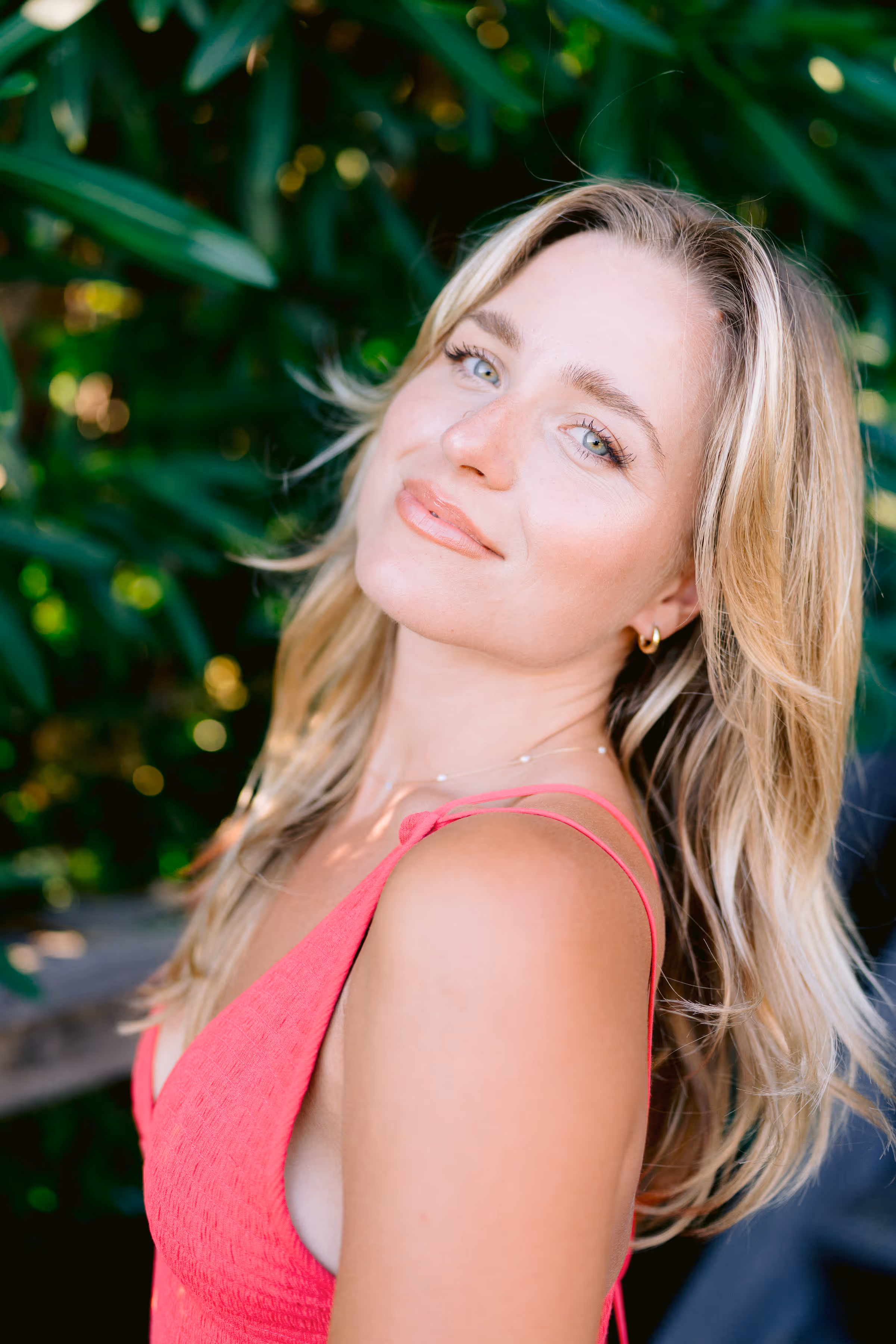 Sloane, founder of Sloane Studio, photographed outdoors against green foliage.